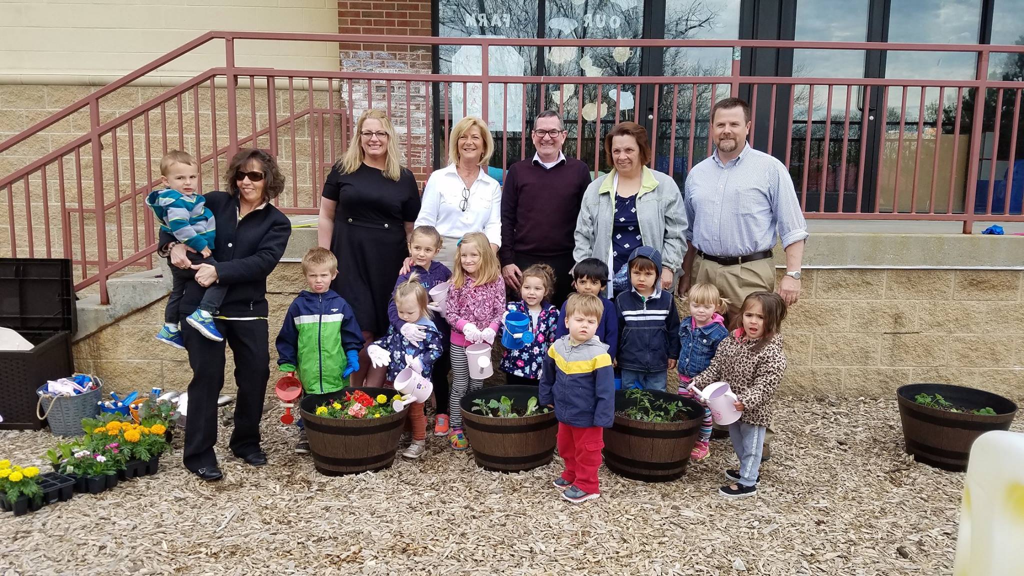 Individualized Early Education in Southeast Wisconsin | Mary Linsmeier staff outside with children who are watering plants.